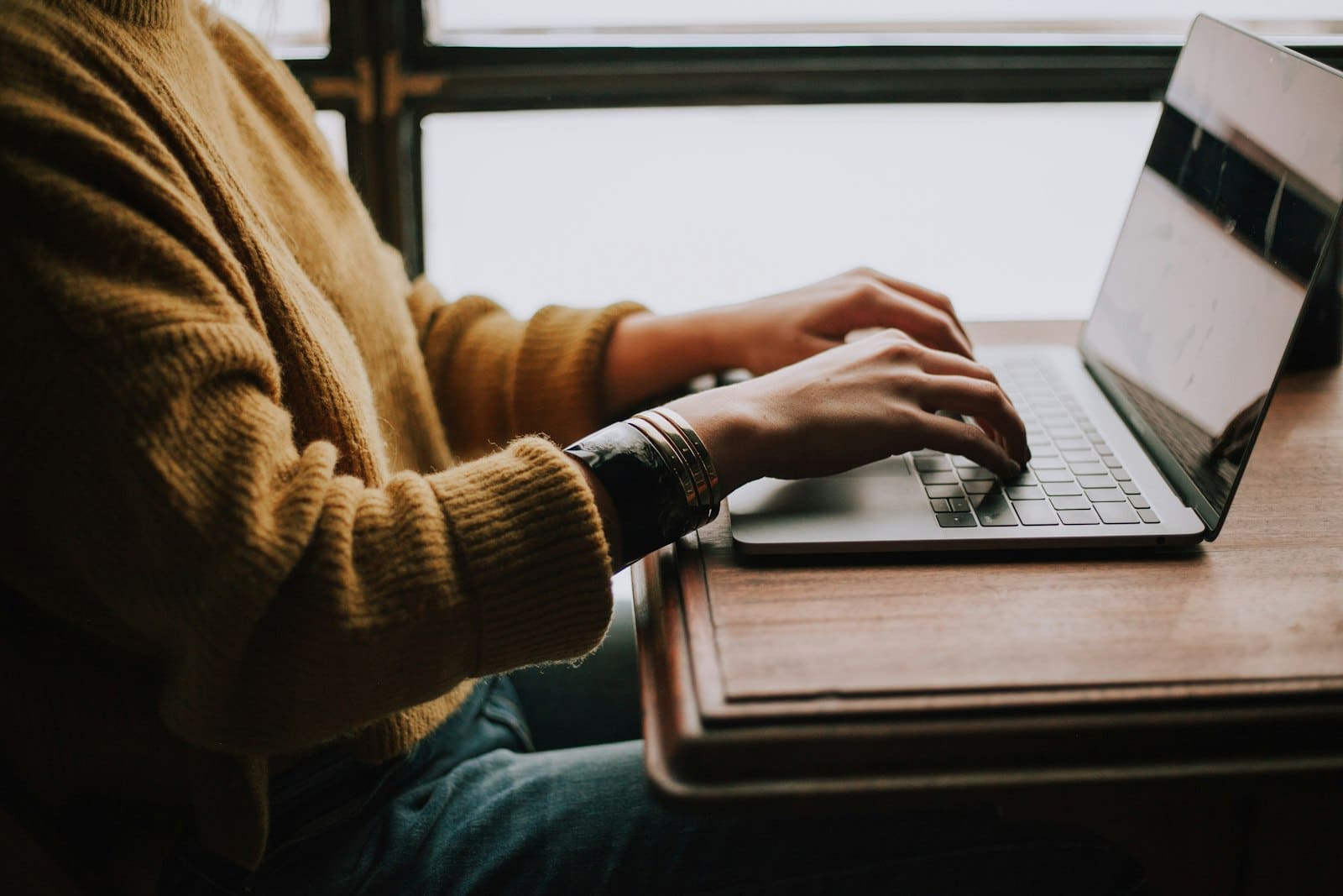 A person typing on a laptop keyboard